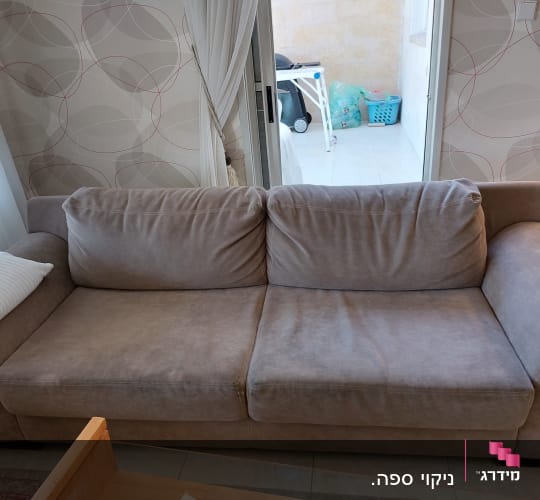ספה אפורה עם כרית לבנה בחדר מגורים